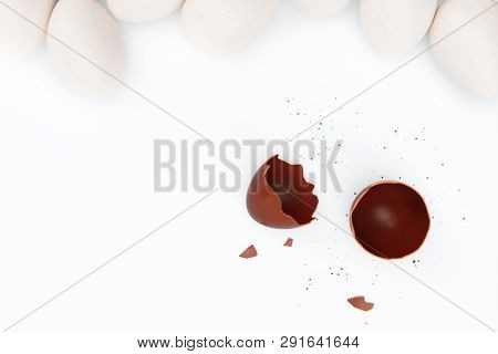 One Chocolate Egg Broken On Two Pieces. Chocolate Egg Around White Eggs, Concept Individuality, Excl