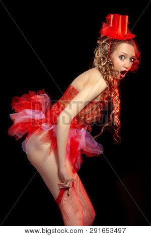 Sexy Burlesque Dancer Stripper Posing With Sweet Lollipop, In Red Corset And Red Hat With Curly Hair