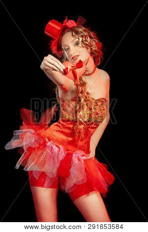 Sexy Burlesque Dancer Stripper Posing With Sweet Lollipop, In Red Corset And Red Hat With Curly Hair