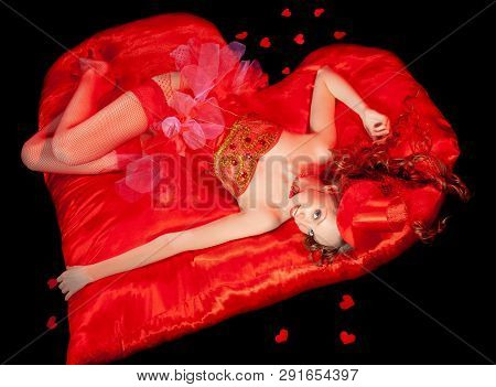 Sexy Burlesque Dancer Stripper Posing With Sweet Lollipop, In Red Corset And Red Hat With Curly Hair