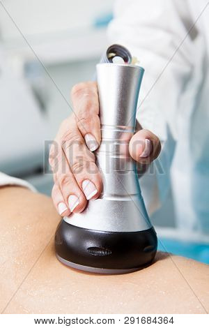 Doctor Performing An  Ultracavitation Treatment On A Young Female Patient Leg