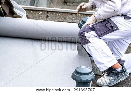 Construction Worker Using Tarpaulin As Covering Sheet To Protect The Ground