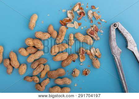 Natural Whole Peanuts In A Shell  On A Blue Background.peel The Peanut From The Shell.healthy Vegan 