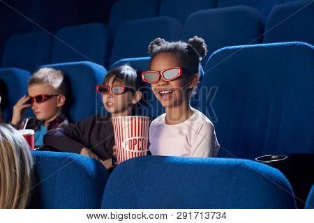 Cheerful, Joyful Children Sitting In Cinema Theatre, Enjoying Movie Or Cartoon. Kids Wearing In 3d G