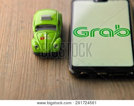 KUALA LUMPUR, MALAYSIA - march 24, 2019 : grab car apps and green taxi toy car, Grab Car, high demand for public transport in Malaysia.