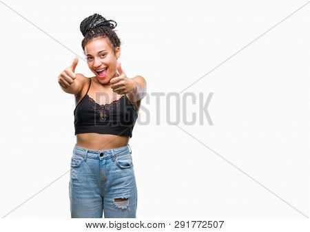 Young braided hair african american with pigmentation blemish birth mark over isolated background approving doing positive gesture with hand, thumbs up smiling and happy for success. Looking