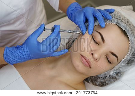 Aesthetic Cosmetology. Facelift In Spa Salon. Beautician Doing Injection Girl In Cheeks. Smoothing O