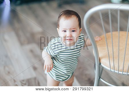 Crying Little Cutie Drk-haired Girl, Stands Crying Loudly, Standing Near Chair At Home