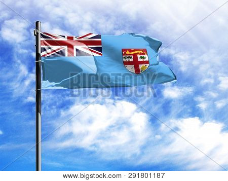 National Flag Of Fiji On A Flagpole In Front Of Blue Sky.