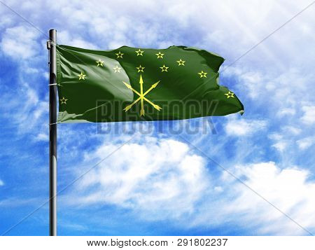 National Flag Of Adygea On A Flagpole In Front Of Blue Sky.