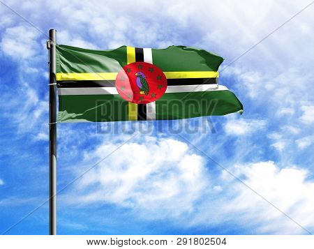 National Flag Of Dominica On A Flagpole In Front Of Blue Sky.