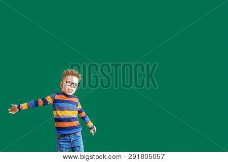 Gamine Boy In Glasses On A Green Background In The Studio. Copy Space.