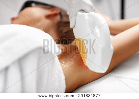 Beautician Giving Epilation Laser Treatment To Woman On Armpits