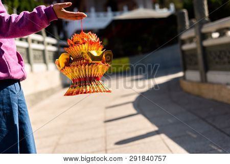 Nantou, Taiwan - FEB 8th, 2019: woman hold a lotus made by joss paper ready for burn at a Baohu Dimu Temple