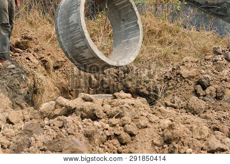 Worker Burying Pipe On Ground For Making Septic Tank At Construction Site