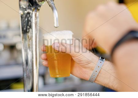 Man Pouring Fresh Beer In Self Service Bar - With All Inclusive Badge