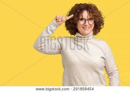 Beautiful middle ager senior woman wearing turtleneck sweater and glasses over isolated background Smiling pointing to head with one finger, great idea or thought, good memory