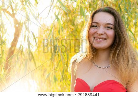 A Woman Is Posing In Front Of A Camera In An Autumn Park. Autumn Photo Shoot. Autumn In The Park.
