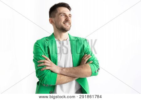 Looking For The Best Moment. Young Dreaming Smiling Man Is Waiting For Chanses Isolated On Gray Back