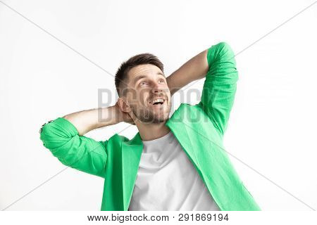 Looking For The Best Moment. Young Dreaming Smiling Man Is Waiting For Chanses Isolated On Gray Back