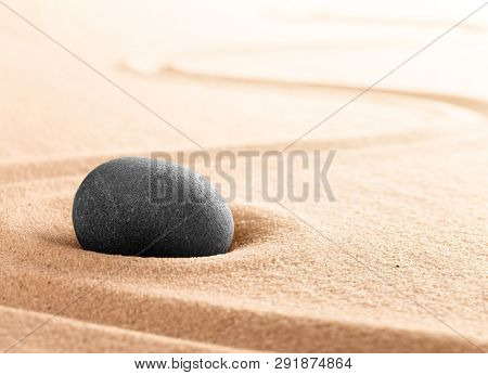 Spa wellness or mindfulness stone and sand garden. Concentration or focus point for spiritual balance and purity of mind and soul. Sandy background with copy space. 