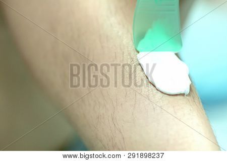 Woman Epilating Leg With Depilation Cream And Spatula. Scrubs Hair Removal Cream
