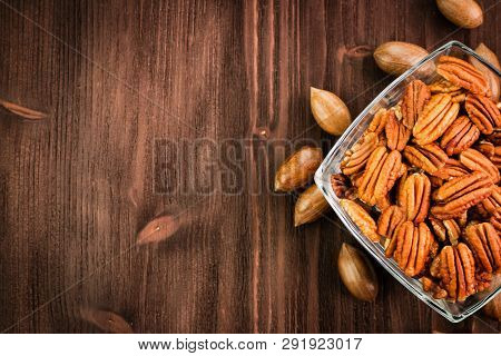 Pecan Nuts In The Shell With Pecan Kernel On Wooden Background