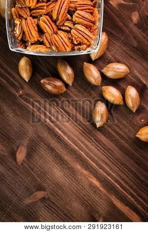 Pecan Nuts In The Shell With Pecan Kernel On Wooden Background