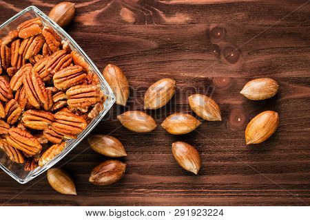 Pecan Nuts In The Shell With Pecan Kernel On Wooden Background
