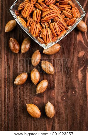 Pecan Nuts In The Shell With Pecan Kernel On Wooden Background