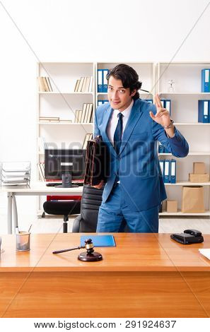 Young handsome judge sitting in courtroom