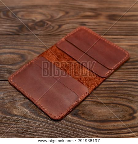 Handmade Ginger Colour Leather Cardholder On Wooden Background. Cardholder Have 4 Pockets For Cards.