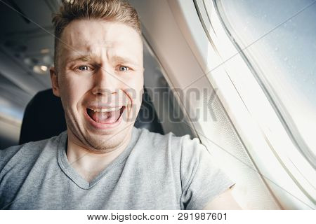 Male Passenger In Plane Screams And Cries, Aerophobia. Background Of Porthole. Concept Fear Of Flyin
