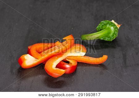 Group Of Four Slices Of Bulgarian Red Bell Pepper On Grey Stone