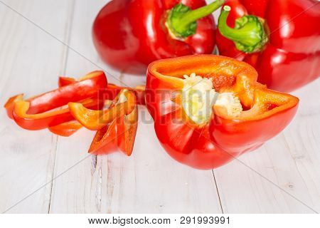 Group Of Two Whole One Half Four Slices Of Bulgarian Red Bell Pepper On White Wood