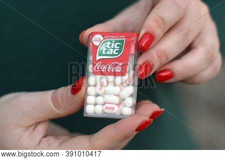 Young Girl Holds Tic-tac Hard Mints Pack With Coca-cola Taste. Tic Tac Is A Brand Of Small Hard Mint