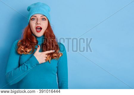 Astonished Caucasian Woman Indicates Away, Shows Blank Space For Your Advertisement, Red Haired With