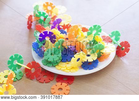 Plastic Flakes Blocks On Plate. Instructive Toy That Promotes Spatial Hhinking And Fine Motor Skills