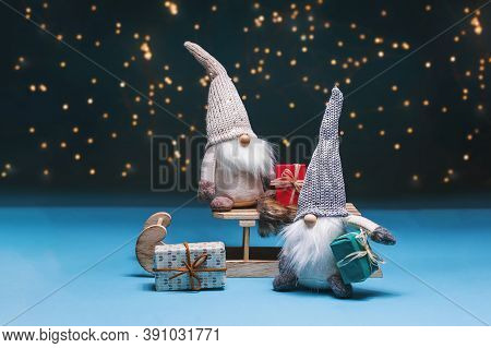 Christmas Composition.tomte Standing Against The Starry Sky With Gifts And Sledges.