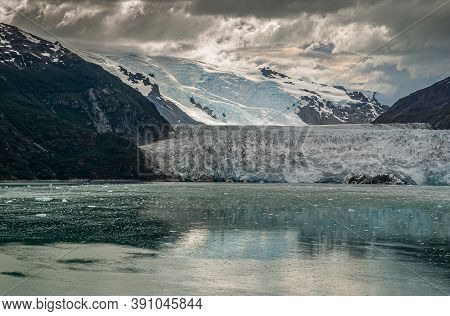 Sarmiento Channel, Chile - December 11, 2008: Amalia Glacier Under Brown Cloudscape Ending In Greeni