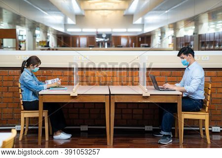 Two Asian University Students Wearing Face Mask And Sitting In Library Social Distance From Other 6 
