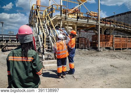 miner at a diamond mine with his African colleagues pointing up