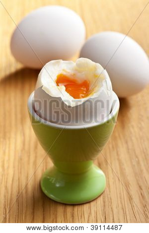 在 eggcup 木桌上的水煮的蛋