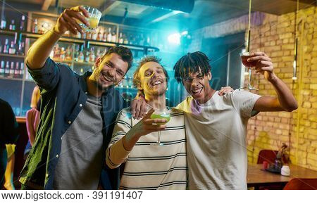 Meet Friends Tonight. Cheerful Young Men Looking At Camera, Posing With Cocktail In Their Hands. Fri