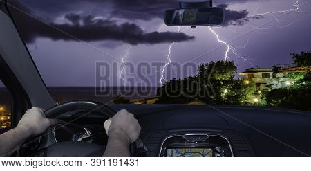Driving A Car Towards A Spectacular Lightning Storm Over The Sea