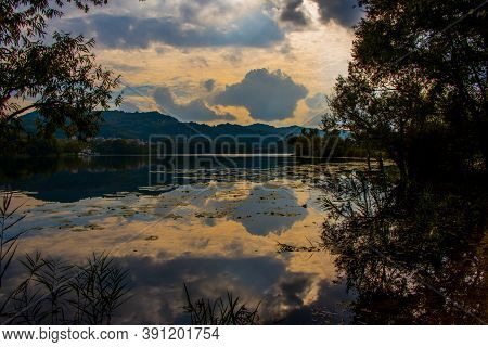 The Clouds Tinged With Orange Are Reflected On The Lakes Of Revine, Treviso, Veneto, Italy