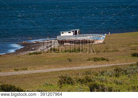 Punta Arenas, Chile - December 12, 2008: Beached Old, Previously Painted Blue And Red, Boat Lies On 