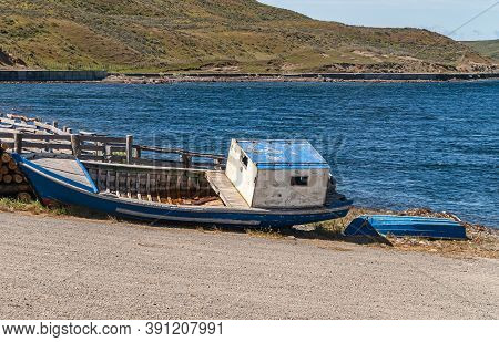 Punta Arenas, Chile - December 12, 2008: Beached Old, Previously Painted Blue And White, Boat Lies O