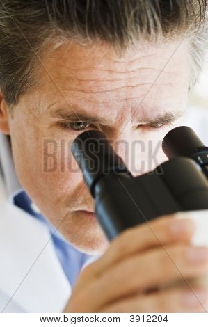 Cientista olhando através do microscópio