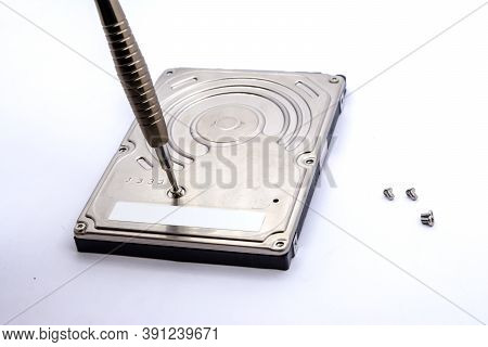 Opening Of Hard Disk For Data Recovery Isolated On White Background. Dismantled Hard Drive. Screwdri